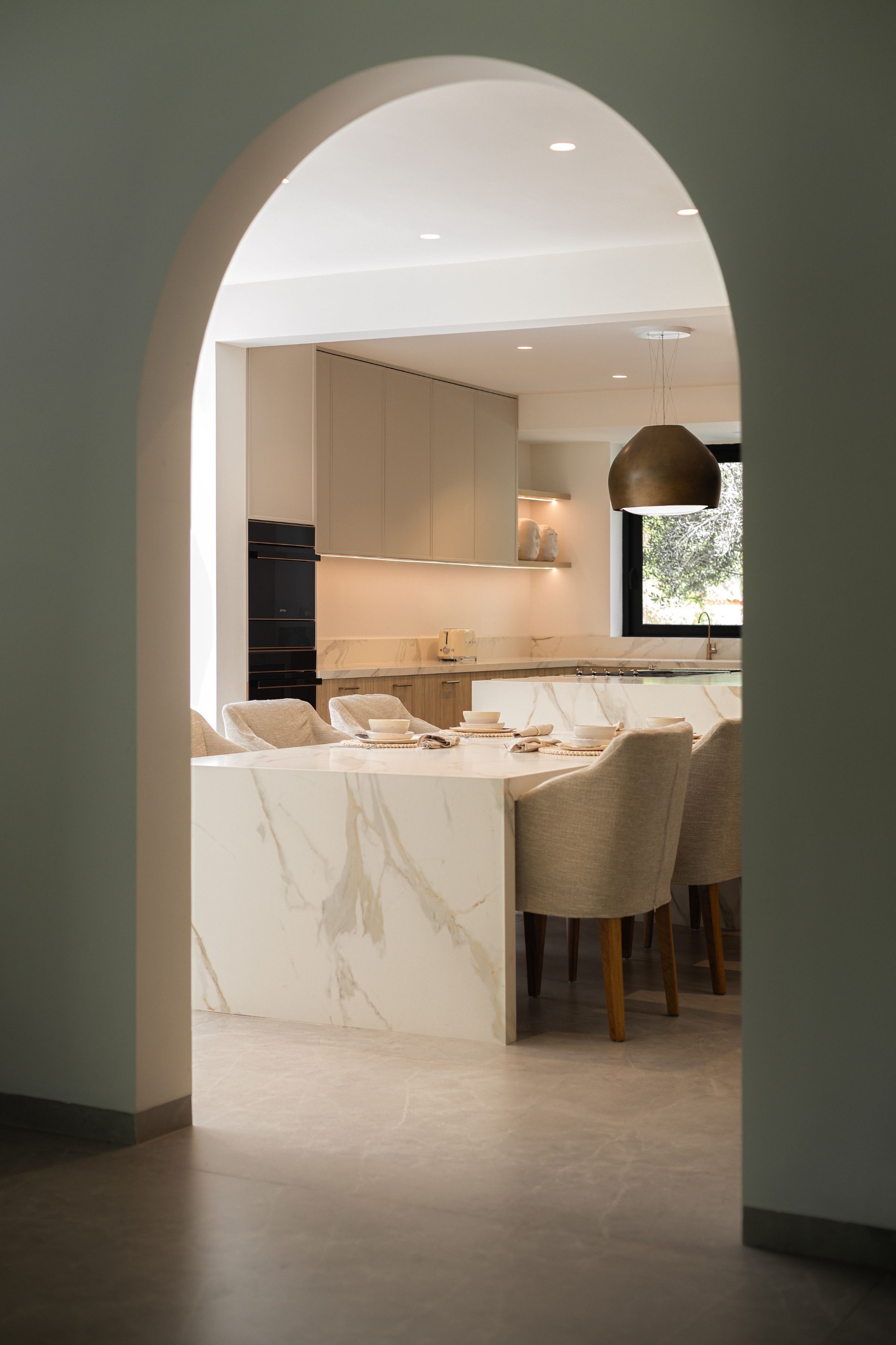 Cocina contemporánea vista a través de un arco arquitectónico